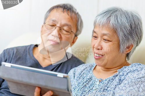Image of Asian elderly couple using digital tablet
