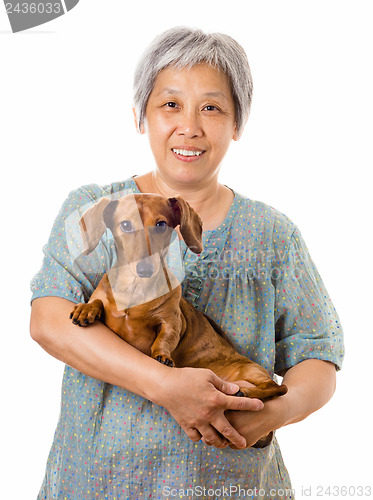 Image of Mature asian woman with dachshund dog