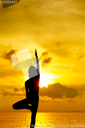 Image of Woman doing yoga at sunset time