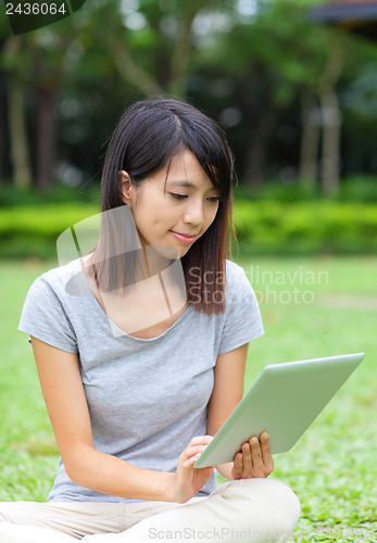 Image of Asian woman looking at computer tablet