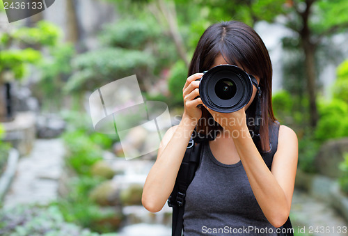 Image of Asian woman taking photo with backpack
