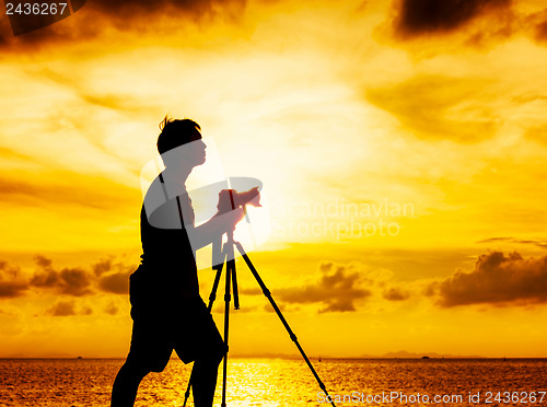 Image of Silhouette of photographer at sunset