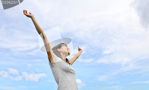 Image of Asian woman hand up with blue sky background
