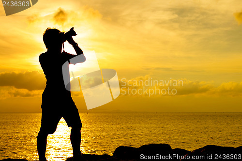 Image of Silhouette of photographer at sunset