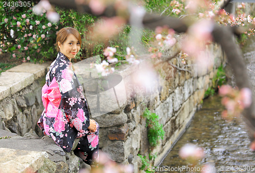 Image of Young woman wearing Japanese kimono with cherry blossom