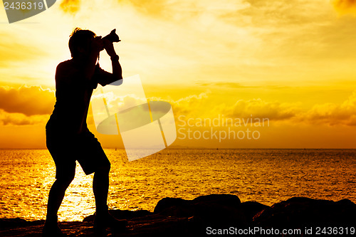 Image of Silhouette of photographer at sunset