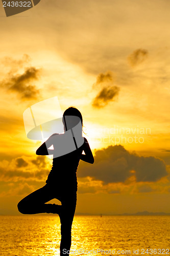 Image of Woman doing yoga at sunset time