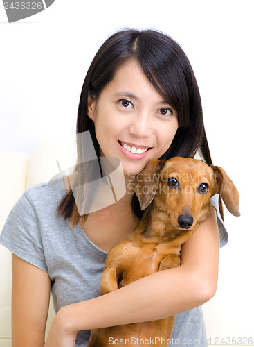 Image of Asian woman with dachshund dog