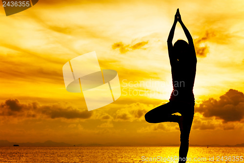 Image of Woman doing yoga at sunset time