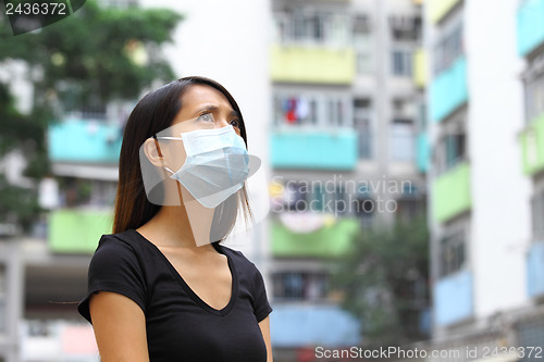 Image of Woman wearing medical face mask in crowded city