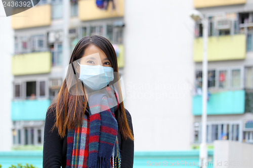 Image of Woman wearing medical face mask in crowded city