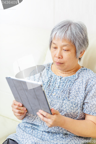 Image of Asian old woman using tablet