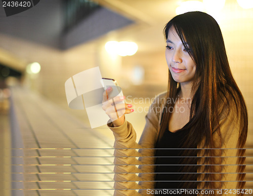 Image of Asian woman using smartphone at night 