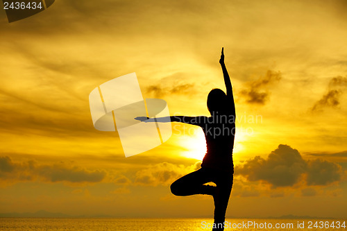 Image of Woman doing yoga at sunset time