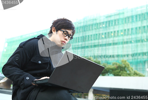 Image of man using computer outdoor