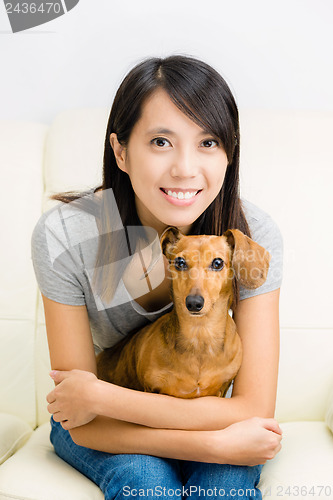 Image of Asian woman and dachshund dog
