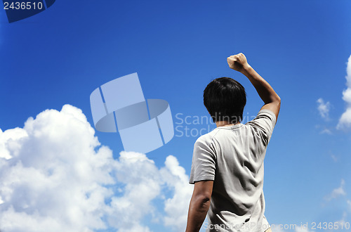 Image of Man clench fist facing the sky