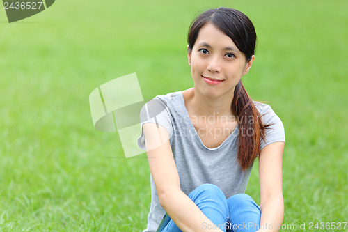 Image of Asian woman setting on the grass 