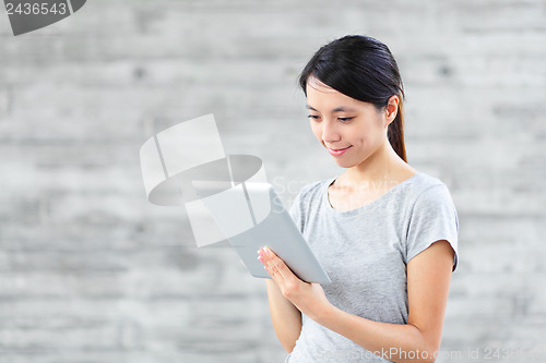 Image of young asian woman using tablet computer