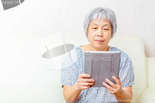 Image of Asian old woman using tablet