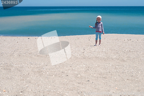 Image of Little girl playing on the beach