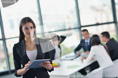 Image of business woman with her staff in background at office