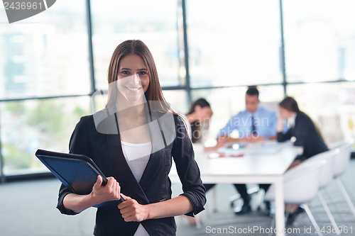 Image of business woman with her staff in background at office