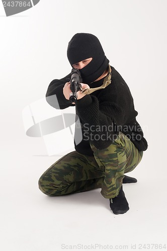 Image of masked man aims with rifle
