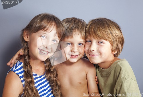 Image of Cute sister hugging younger brothers