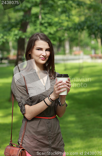 Image of Young Woman with a Coffee Cup in Park
