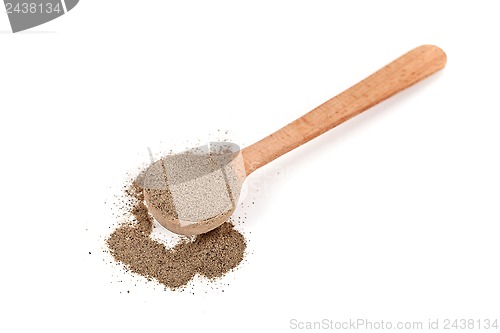 Image of milled black pepper in wooden spoon 