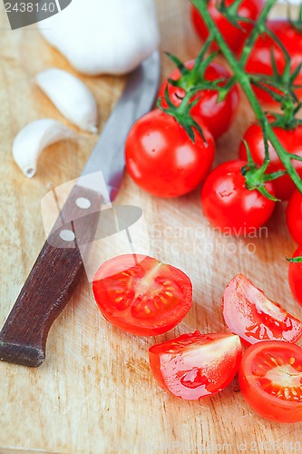 Image of fresh tomatoes, garlic and old knife 