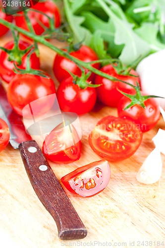 Image of fresh tomatoes, rucola, garlic and old knife 