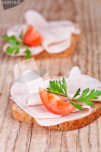 Image of bread with sliced ham, fresh tomatoes and parsley