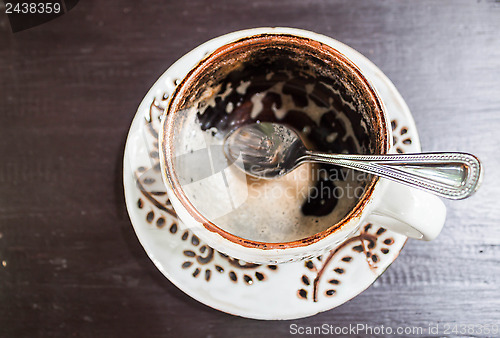 Image of Drinking out of hot espresso cup on wooden table