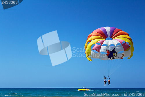 Image of Big beautiful parachute in the air over the sea.