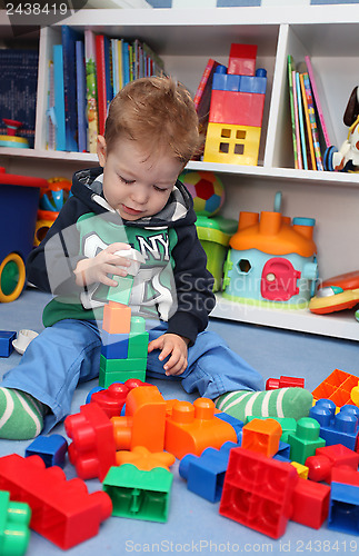Image of A baby boy playing with plastic blocks