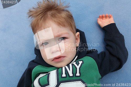 Image of A baby boy crying on a floor 