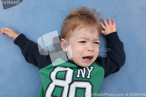 Image of A baby boy crying on a floor