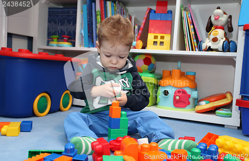Image of A baby boy playing with plastic blocks