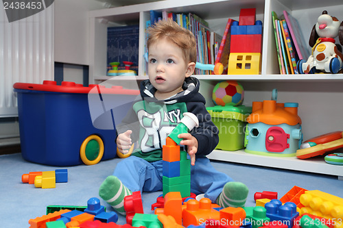 Image of A baby boy playing with plastic blocks
