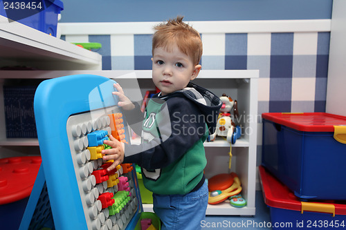 Image of A baby boy playing with plastic blocks