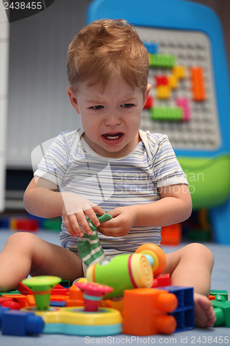 Image of A baby boy crying in children's room