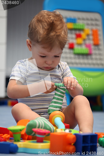 Image of A funny baby boy trying to dress socks