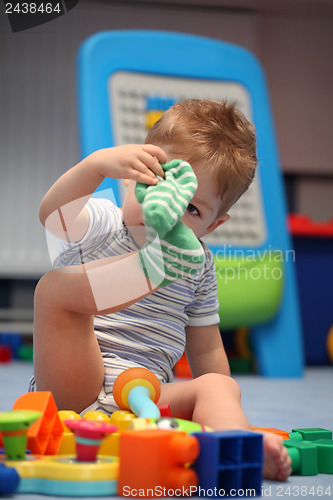 Image of A funny baby boy trying to dress socks