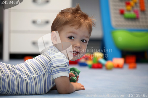 Image of A happy baby boy lying on a floor