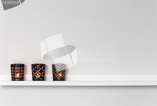 Image of Candle lights on white shelf