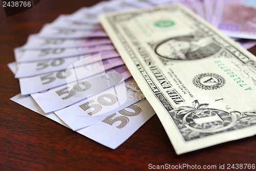 Image of dollar and grivnas banknotes on dark background