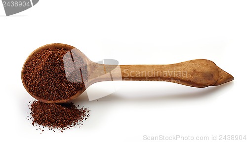 Image of wooden scoop with ground coffee