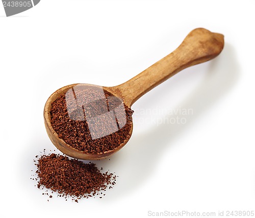 Image of wooden scoop with ground coffee